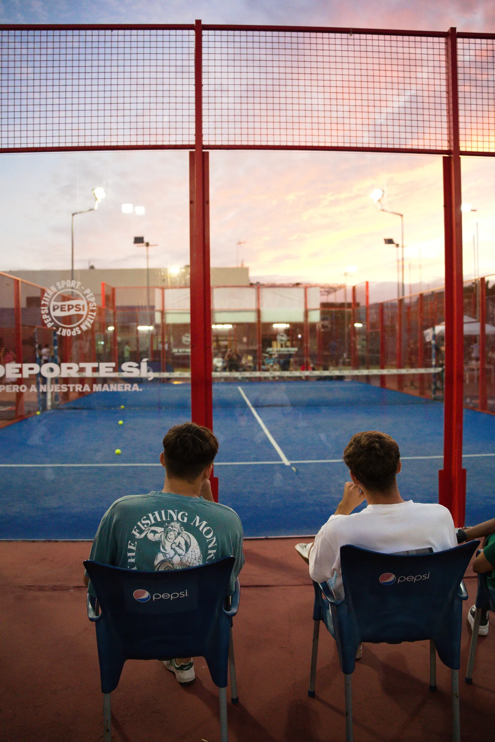 Dos amigos viendo un partido al atardecer en la I edición